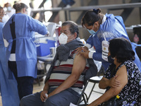 A person receives a dose of Pfizer-BioNTech Covid-19 vaccine before inject to an elderly, during mass vaccine inside of Hermanos Lopez Rayon...