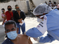 A person receives a dose of Pfizer-BioNTech Covid-19 vaccine before inject to an elderly, during mass vaccine inside of Hermanos Lopez Rayon...