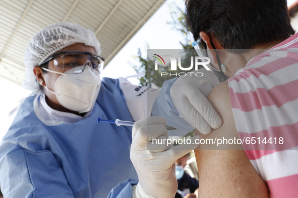 A person receives a dose of Pfizer-BioNTech Covid-19 vaccine before inject to an elderly, during mass vaccine inside of Hermanos Lopez Rayon...