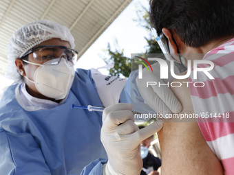 A person receives a dose of Pfizer-BioNTech Covid-19 vaccine before inject to an elderly, during mass vaccine inside of Hermanos Lopez Rayon...