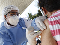 A person receives a dose of Pfizer-BioNTech Covid-19 vaccine before inject to an elderly, during mass vaccine inside of Hermanos Lopez Rayon...