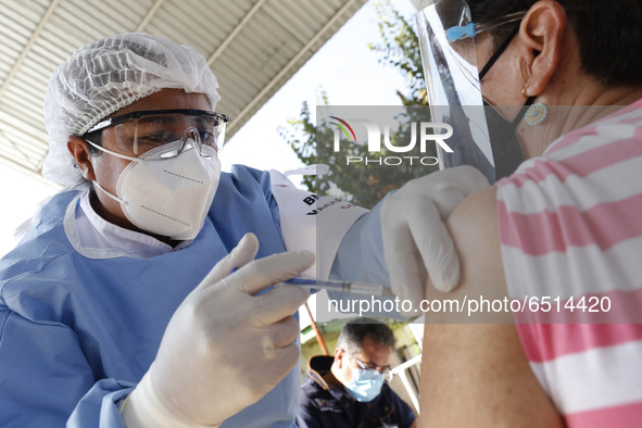 A person receives a dose of Pfizer-BioNTech Covid-19 vaccine before inject to an elderly, during mass vaccine inside of Hermanos Lopez Rayon...