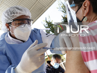 A person receives a dose of Pfizer-BioNTech Covid-19 vaccine before inject to an elderly, during mass vaccine inside of Hermanos Lopez Rayon...