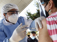 A person receives a dose of Pfizer-BioNTech Covid-19 vaccine before inject to an elderly, during mass vaccine inside of Hermanos Lopez Rayon...