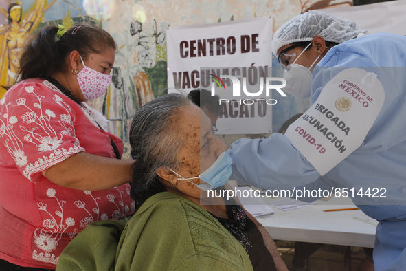 A person receives a dose of Pfizer-BioNTech Covid-19 vaccine before inject to an elderly, during mass vaccine inside of Hermanos Lopez Rayon...