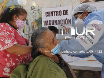 A person receives a dose of Pfizer-BioNTech Covid-19 vaccine before inject to an elderly, during mass vaccine inside of Hermanos Lopez Rayon...