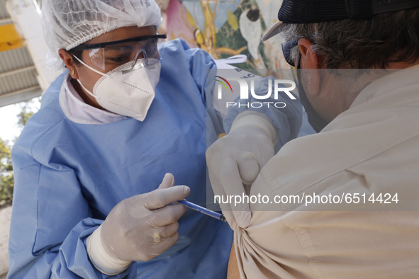 A person receives a dose of Pfizer-BioNTech Covid-19 vaccine before inject to an elderly, during mass vaccine inside of Hermanos Lopez Rayon...