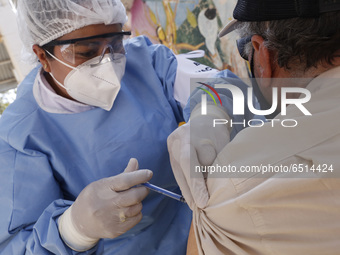 A person receives a dose of Pfizer-BioNTech Covid-19 vaccine before inject to an elderly, during mass vaccine inside of Hermanos Lopez Rayon...