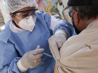 A person receives a dose of Pfizer-BioNTech Covid-19 vaccine before inject to an elderly, during mass vaccine inside of Hermanos Lopez Rayon...