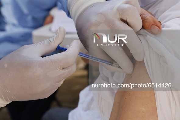 A person receives a dose of Pfizer-BioNTech Covid-19 vaccine before inject to an elderly, during mass vaccine inside of Hermanos Lopez Rayon...