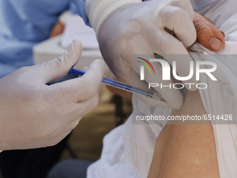 A person receives a dose of Pfizer-BioNTech Covid-19 vaccine before inject to an elderly, during mass vaccine inside of Hermanos Lopez Rayon...