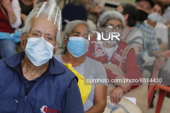 Persons wait  receive  a dose of Pfizer-BioNTech Covid-19 vaccine   during mass vaccine inside of Hermanos Lopez Rayon sports center, a desi...