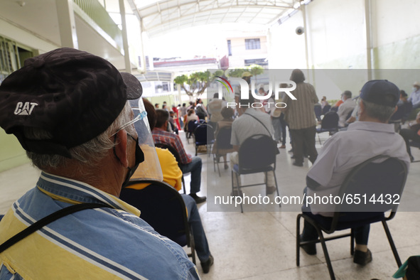 Persons wait  receive  a dose of Pfizer-BioNTech Covid-19 vaccine   during mass vaccine inside of Hermanos Lopez Rayon sports center, a desi...