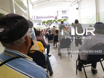 Persons wait  receive  a dose of Pfizer-BioNTech Covid-19 vaccine   during mass vaccine inside of Hermanos Lopez Rayon sports center, a desi...