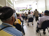 Persons wait  receive  a dose of Pfizer-BioNTech Covid-19 vaccine   during mass vaccine inside of Hermanos Lopez Rayon sports center, a desi...