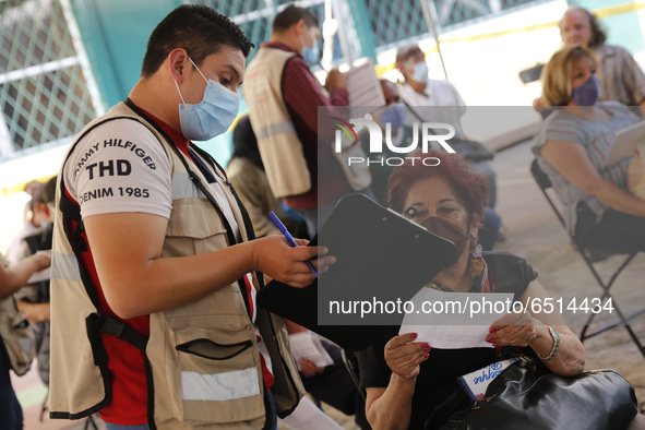 A elderly fill out a form after receive a dose of Pfizer-BioNTech Covid-19 vaccine, during mass vaccine inside of Hermanos Lopez Rayon sport...