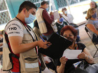 A elderly fill out a form after receive a dose of Pfizer-BioNTech Covid-19 vaccine, during mass vaccine inside of Hermanos Lopez Rayon sport...