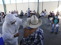 A person receives a dose of Pfizer-BioNTech Covid-19 vaccine before inject to an elderly, during mass vaccine inside of Hermanos Lopez Rayon...