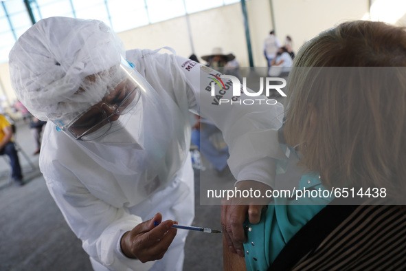 A person receives a dose of Pfizer-BioNTech Covid-19 vaccine before inject to an elderly, during mass vaccine inside of Hermanos Lopez Rayon...