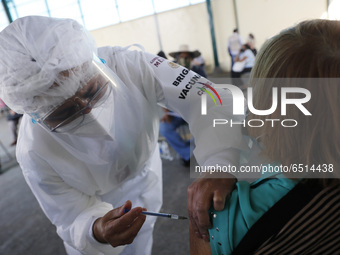 A person receives a dose of Pfizer-BioNTech Covid-19 vaccine before inject to an elderly, during mass vaccine inside of Hermanos Lopez Rayon...