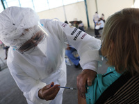 A person receives a dose of Pfizer-BioNTech Covid-19 vaccine before inject to an elderly, during mass vaccine inside of Hermanos Lopez Rayon...