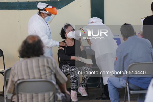 A person receives a dose of Pfizer-BioNTech Covid-19 vaccine before inject to an elderly, during mass vaccine inside of Hermanos Lopez Rayon...