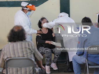 A person receives a dose of Pfizer-BioNTech Covid-19 vaccine before inject to an elderly, during mass vaccine inside of Hermanos Lopez Rayon...