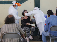 A person receives a dose of Pfizer-BioNTech Covid-19 vaccine before inject to an elderly, during mass vaccine inside of Hermanos Lopez Rayon...