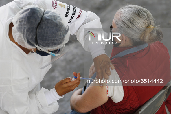 A person receives a dose of Pfizer-BioNTech Covid-19 vaccine before inject to an elderly, during mass vaccine inside of Hermanos Lopez Rayon...