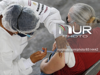 A person receives a dose of Pfizer-BioNTech Covid-19 vaccine before inject to an elderly, during mass vaccine inside of Hermanos Lopez Rayon...