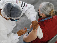 A person receives a dose of Pfizer-BioNTech Covid-19 vaccine before inject to an elderly, during mass vaccine inside of Hermanos Lopez Rayon...