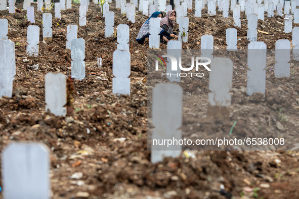 Families member of Covid19 Death Victim visiting the grave at Srengseng Sawah, Jakarta, Indonesia on March 19, 2021. Number of covid19 death...