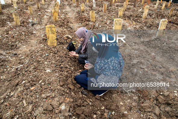 Families member of Covid19 Death Victim visiting the grave at Srengseng Sawah, Jakarta, Indonesia on March 19, 2021. Number of covid19 death...