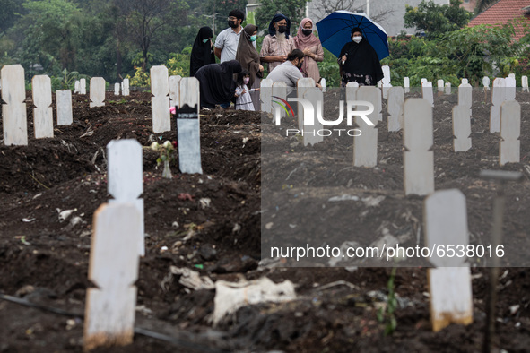 Families member of Covid19 Death Victim visiting the grave at Srengseng Sawah, Jakarta, Indonesia on March 19, 2021. Number of covid19 death...