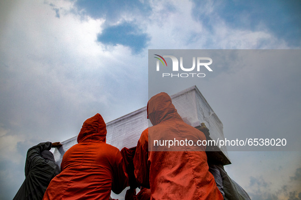 Grave digger carried out the coffin. Burrial process of a victim of Covid19 at Srengsawah, South Jakarta, Indonesia on March 19, 2021. Numbe...