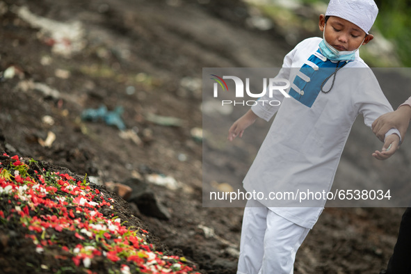 A child cried in front of his grandma grave. Burrial process of a victim of Covid19 at Srengsawah, South Jakarta, Indonesia on March 19, 202...