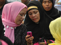 MANILA, Philippines - Muslim women check their mobile phones as Filipino Muslims take part in a rally as they celebrate in Mendiola bridge i...