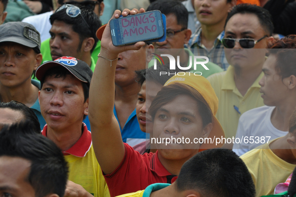 MANILA, Philippines - A man holds up his mobile phone containing the word 