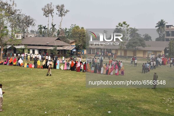 oters wait in queue to cast their ballots at a polling station during Phase 1 of Assam's legislative election in Nagaon district, in the nor...