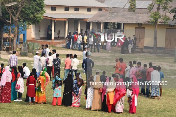 oters wait in queue to cast their ballots at a polling station during Phase 1 of Assam's legislative election in Nagaon district, in the nor...