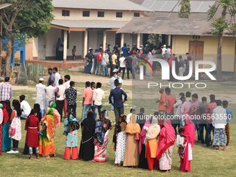 oters wait in queue to cast their ballots at a polling station during Phase 1 of Assam's legislative election in Nagaon district, in the nor...