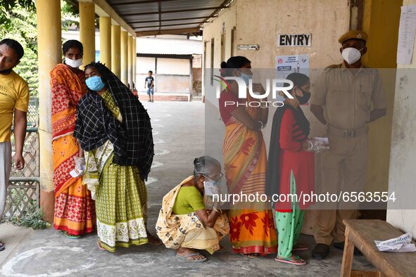 oters wait in queue to cast their ballots at a polling station during Phase 1 of Assam's legislative election in Nagaon district, in the nor...