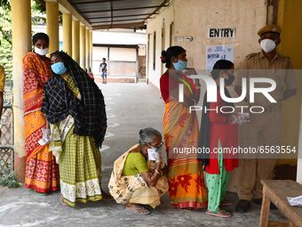 oters wait in queue to cast their ballots at a polling station during Phase 1 of Assam's legislative election in Nagaon district, in the nor...