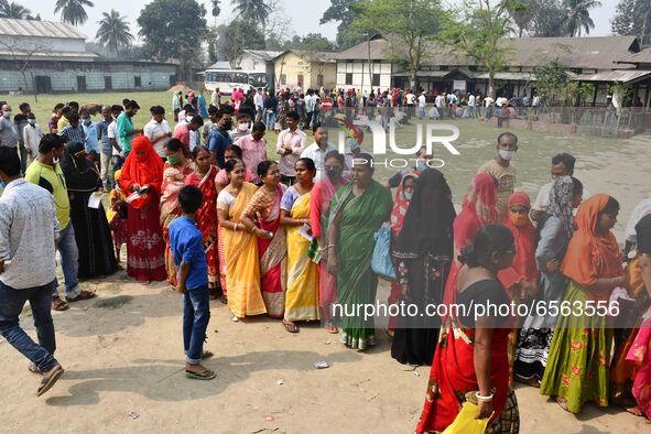 oters wait in queue to cast their ballots at a polling station during Phase 1 of Assam's legislative election in Nagaon district, in the nor...