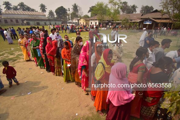 oters wait in queue to cast their ballots at a polling station during Phase 1 of Assam's legislative election in Nagaon district, in the nor...