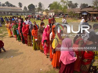 oters wait in queue to cast their ballots at a polling station during Phase 1 of Assam's legislative election in Nagaon district, in the nor...