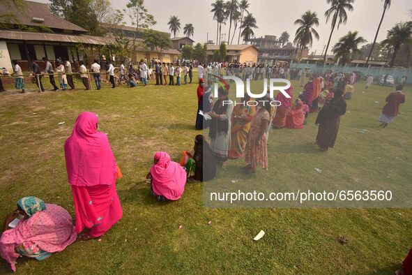 oters wait in queue to cast their ballots at a polling station during Phase 1 of Assam's legislative election in Nagaon district, in the nor...