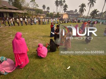 oters wait in queue to cast their ballots at a polling station during Phase 1 of Assam's legislative election in Nagaon district, in the nor...