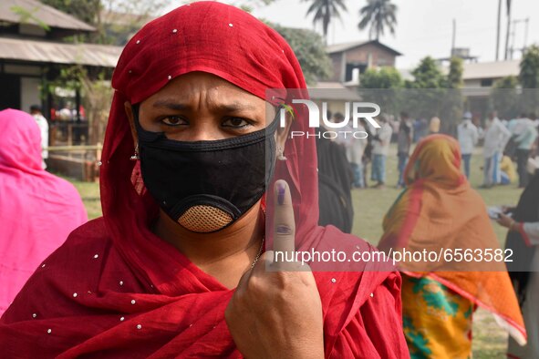 Woman voters hold up inked fingers after casting ballot  in the first  phase of polling for Assam Assembly Elections, at  Rupohi   constitue...