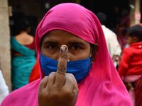 Woman voters hold up inked fingers after casting ballot  in the first  phase of polling for Assam Assembly Elections, at  Rupohi   constitue...